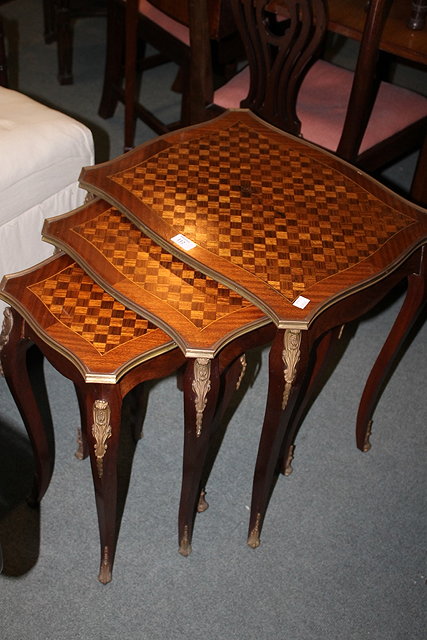 Appraisal: A NEST OF THREE FRENCH OCCASIONAL TABLES with applied brass