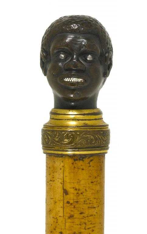 Appraisal: A MALACCA CANE the parcel gilt bronze negro's head pommel