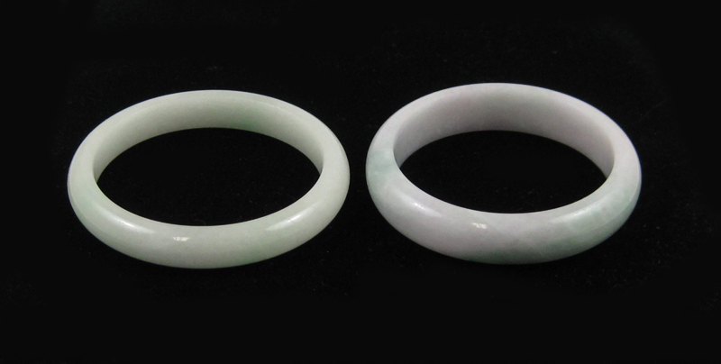 Appraisal: TWO CHINESE GREEN JADE BANGLES each of plain circular form