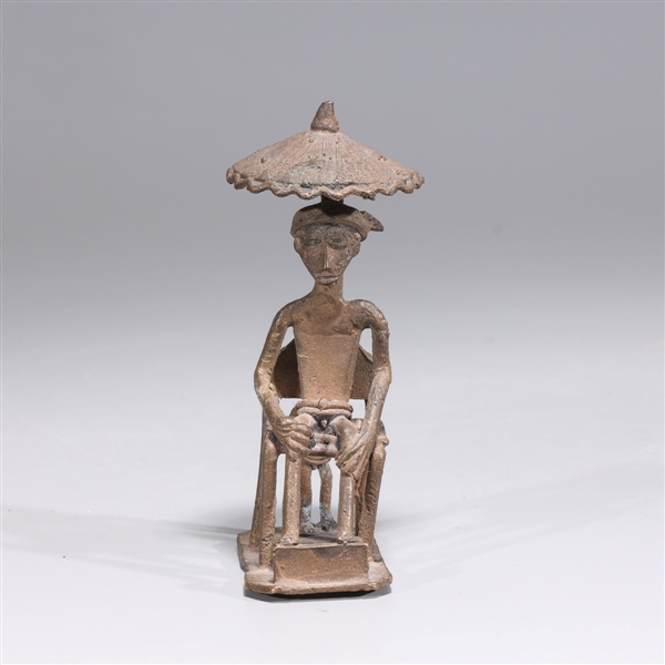 Appraisal: African bronze statue of a figure seated beneath an umbrella