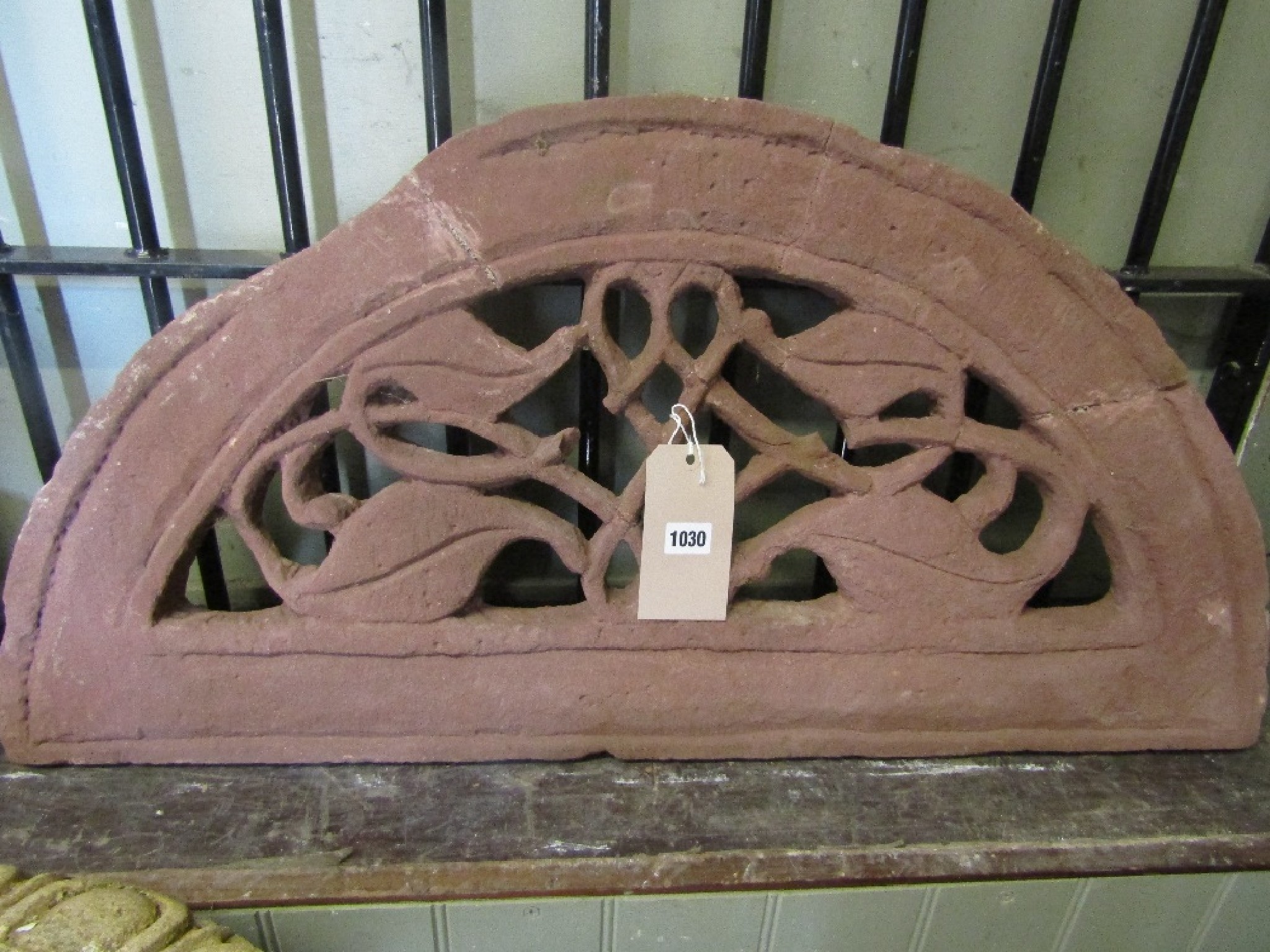 Appraisal: A small red sandstone architectural and ornamental arch with scrolling