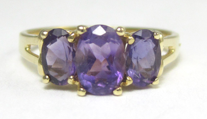 Appraisal: AMETHYST AND TEN KARAT GOLD RING set with three oval-cut