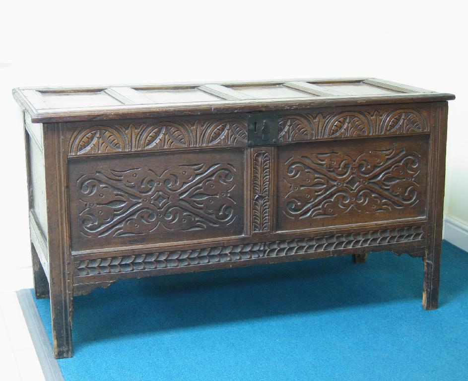 Appraisal: An antique oak Coffer with panelled top and carved panelled