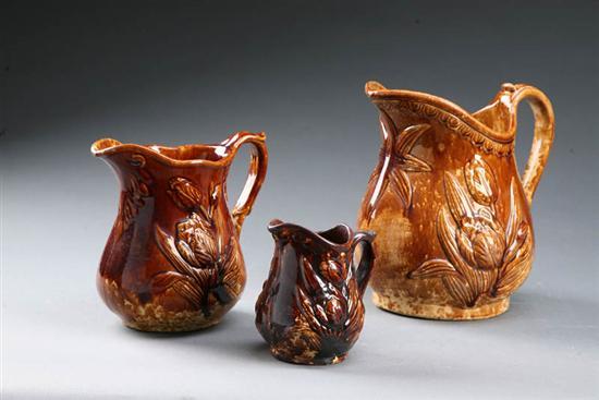 Appraisal: THREE ROCKINGHAM TULIP PITCHERS American mid th century ceramic Graduated