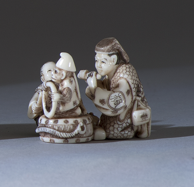 Appraisal: POLYCHROME IVORY NETSUKE Depicting a Sarumawashi entertainer with a flute