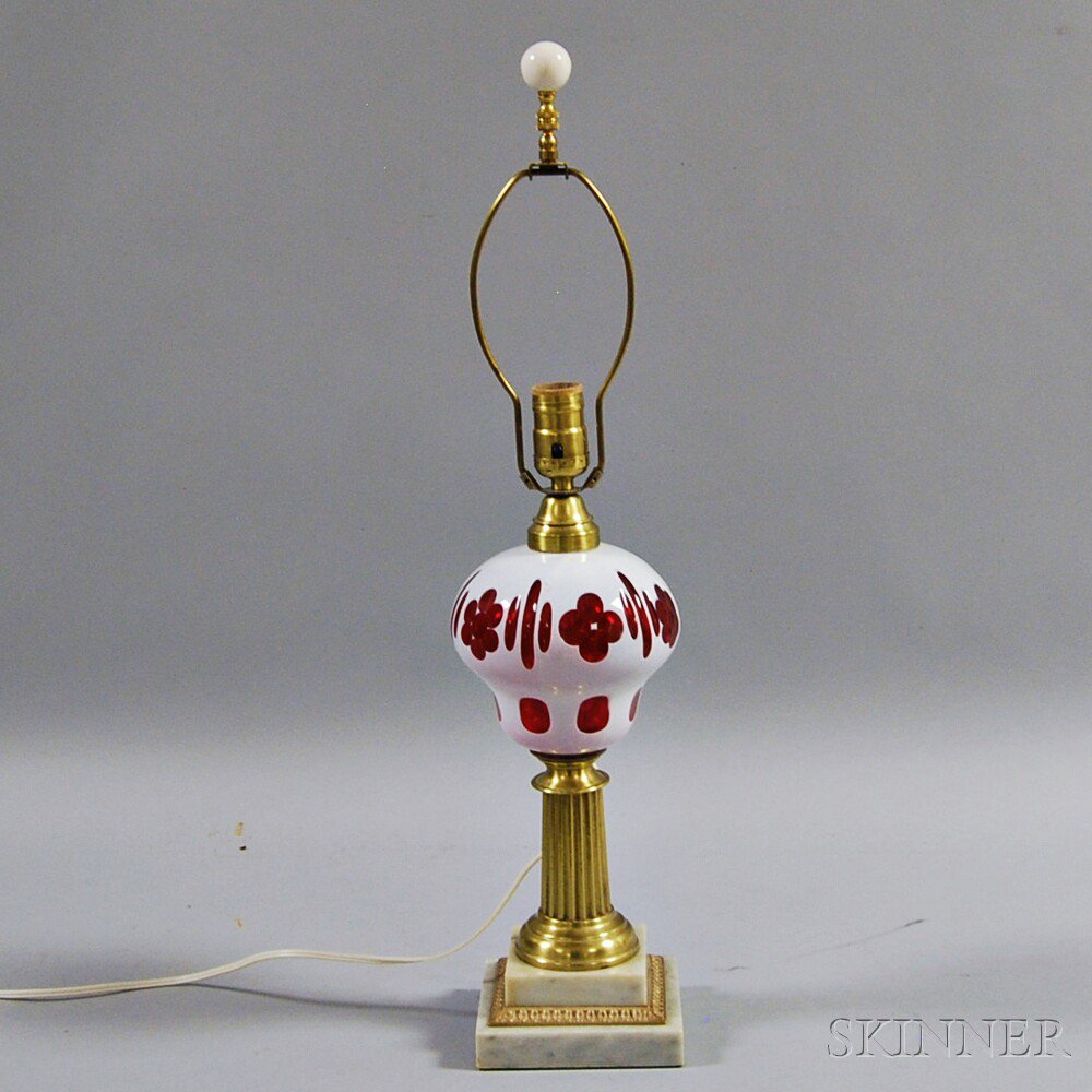 Appraisal: White Cut-to-Cranberry Glass Lamp the reservoir raised on a brass