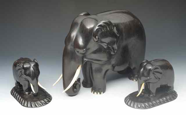 Appraisal: A CARVED EBONY ELEPHANT high together with two smaller elephants