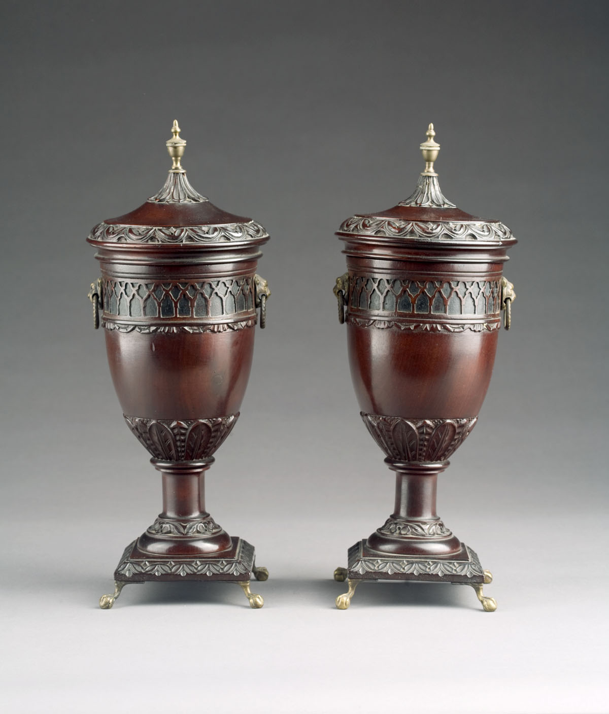 Appraisal: PAIR OF REGENCY STYLE CARVED MAHOGANY URNS AND COVERS Each