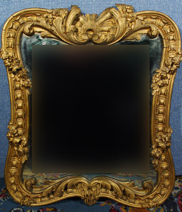 Appraisal: Shaped rectangular gilded wooden framed mirror the frame carved with