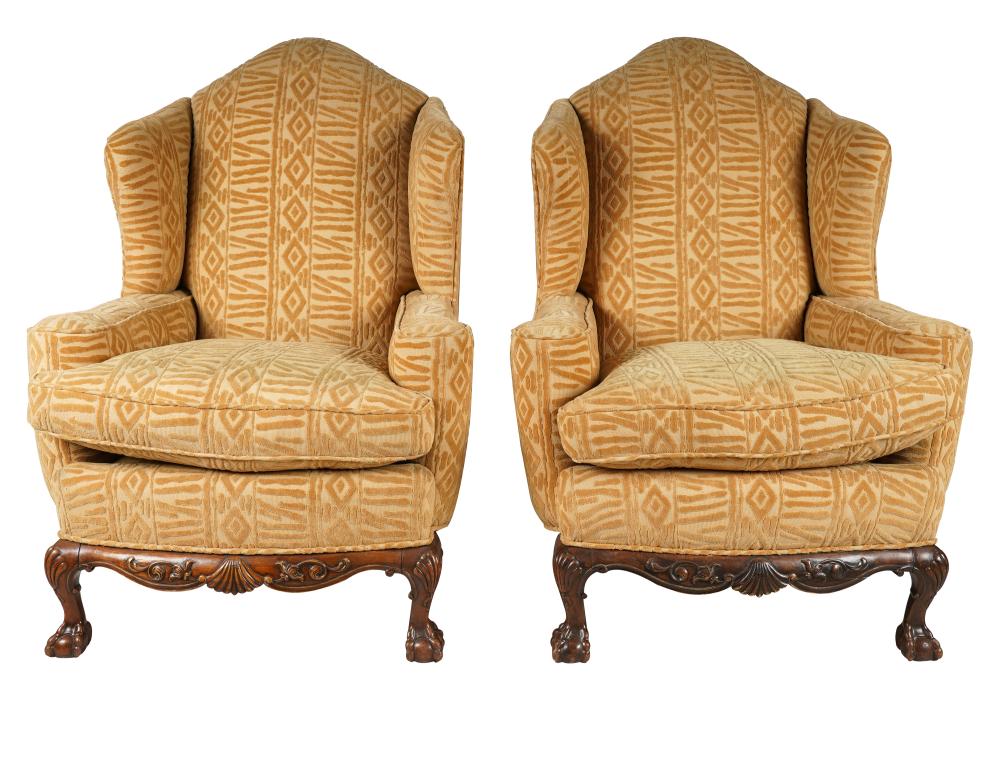 Appraisal: PAIR OF CARVED MAHOGANY UPHOLSTERED WINGCHAIRShaving yellow textured upholstery ball