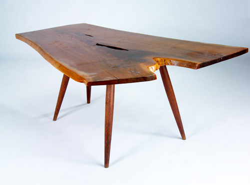 Appraisal: GEORGE NAKASHIMA Early walnut dining table with a crotch-figured free-edge