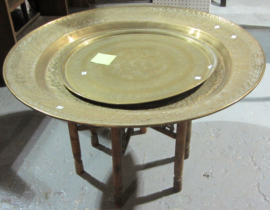 Appraisal: An Eastern brass folding tray table and a similar brass