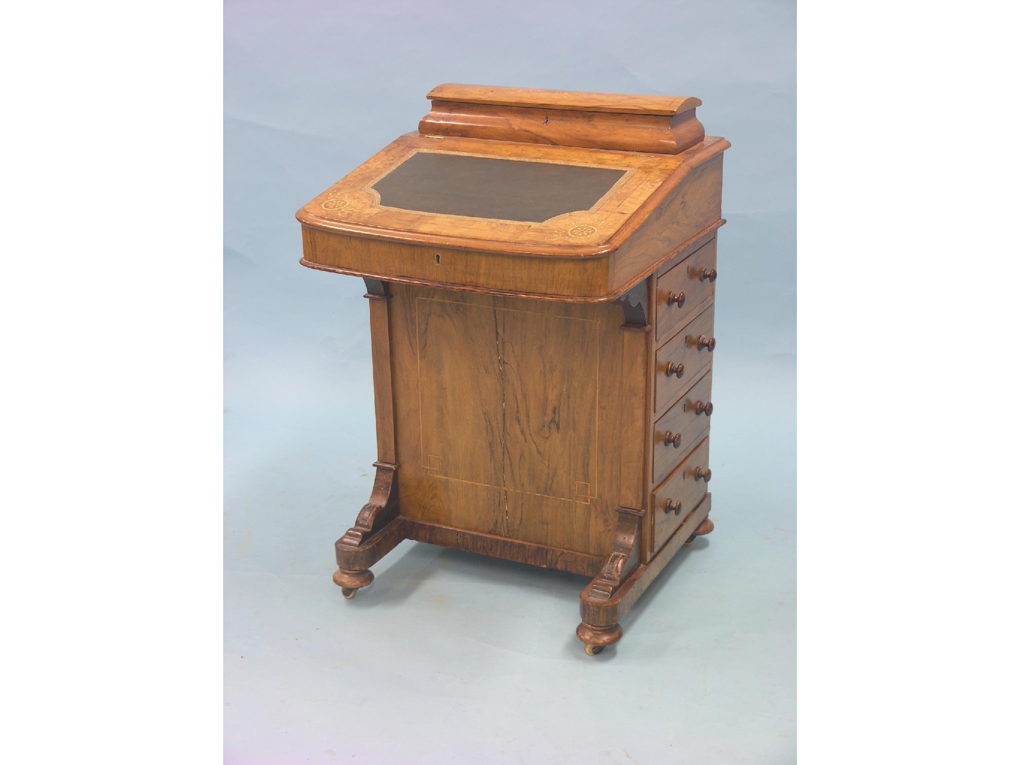 Appraisal: A Victorian walnut Davenport enclosed stationery compartment and sloping writing