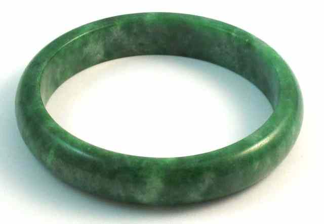 Appraisal: HEAVY GREEN JADE BANGLE The round bangle is - ''