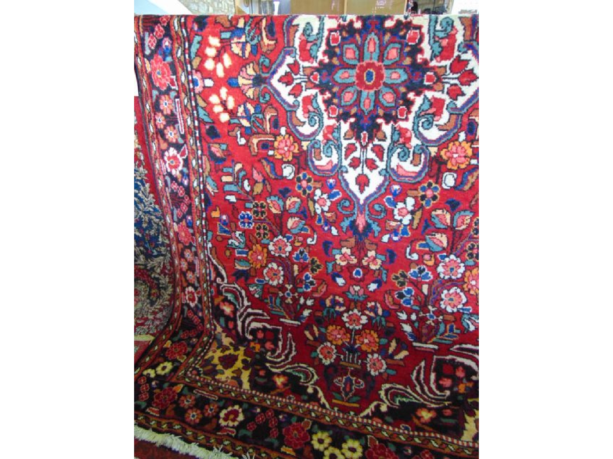 Appraisal: A Persian style wool carpet with bright red field central