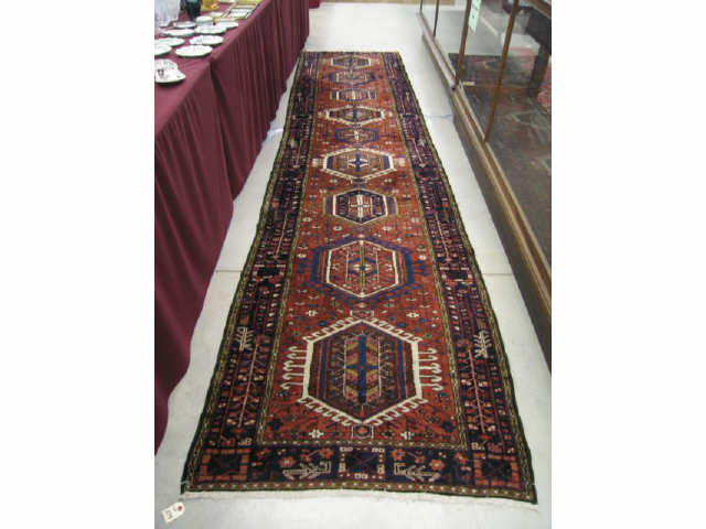 Appraisal: Heriz Persian Handmade Runner geometric medallions reds blues ivory '