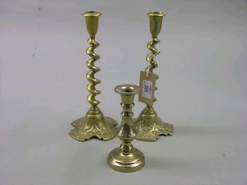 Appraisal: A pair of brass candlesticks with single-bine spiral-twist stems in