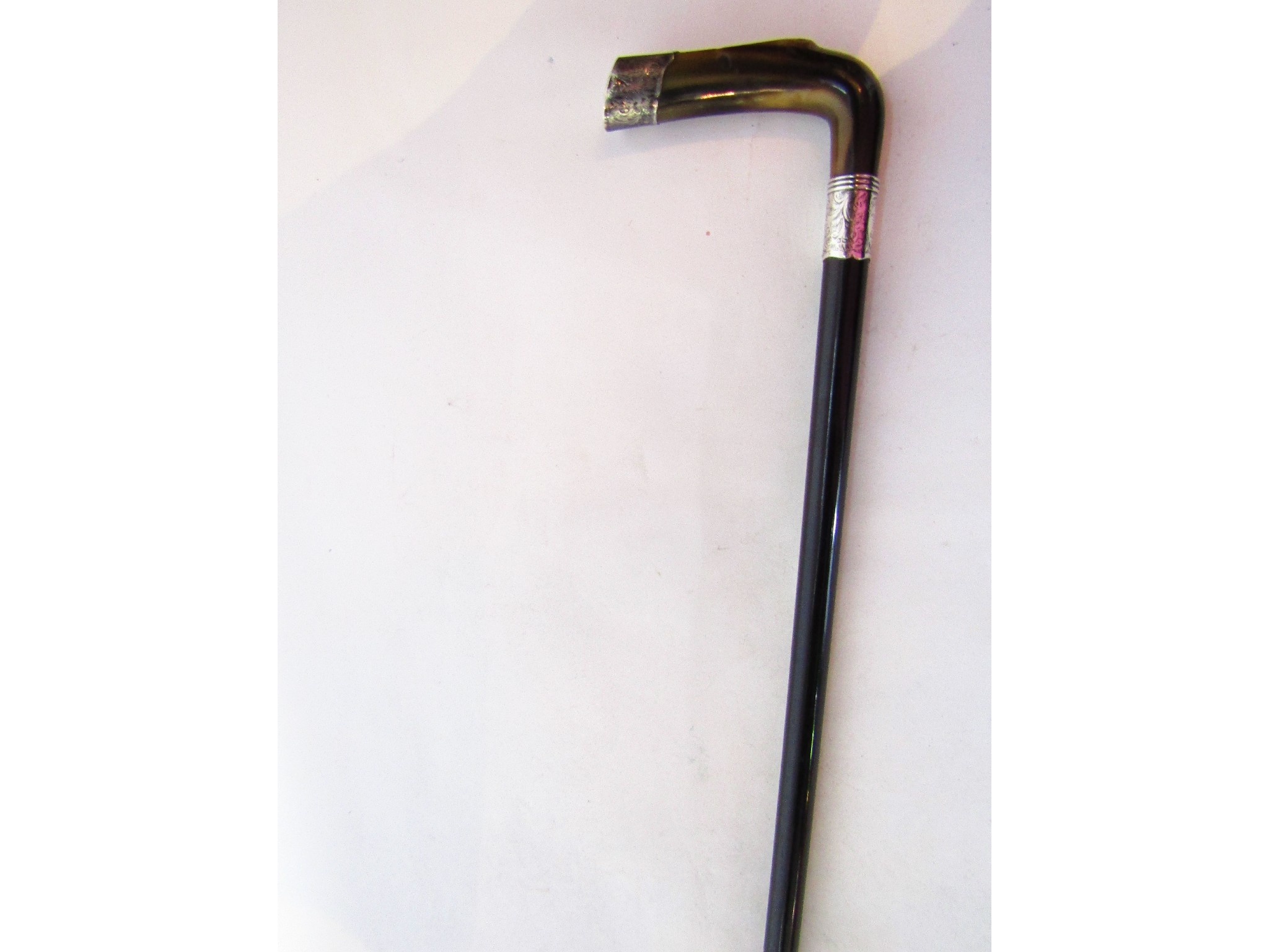 Appraisal: An ebonised walking cane with shaped polished horn handle with