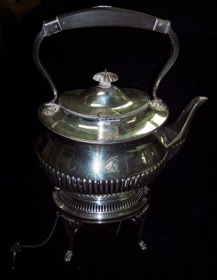 Appraisal: A half ribbed tea kettle with cross over handle on