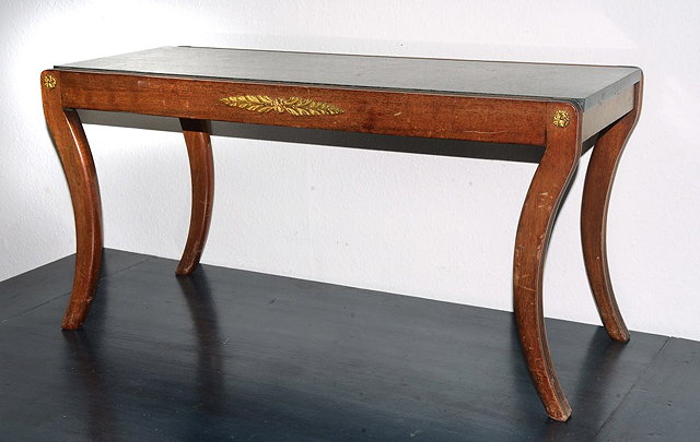 Appraisal: A MAHOGANY COFFEE TABLE with sabre legs and inset marble