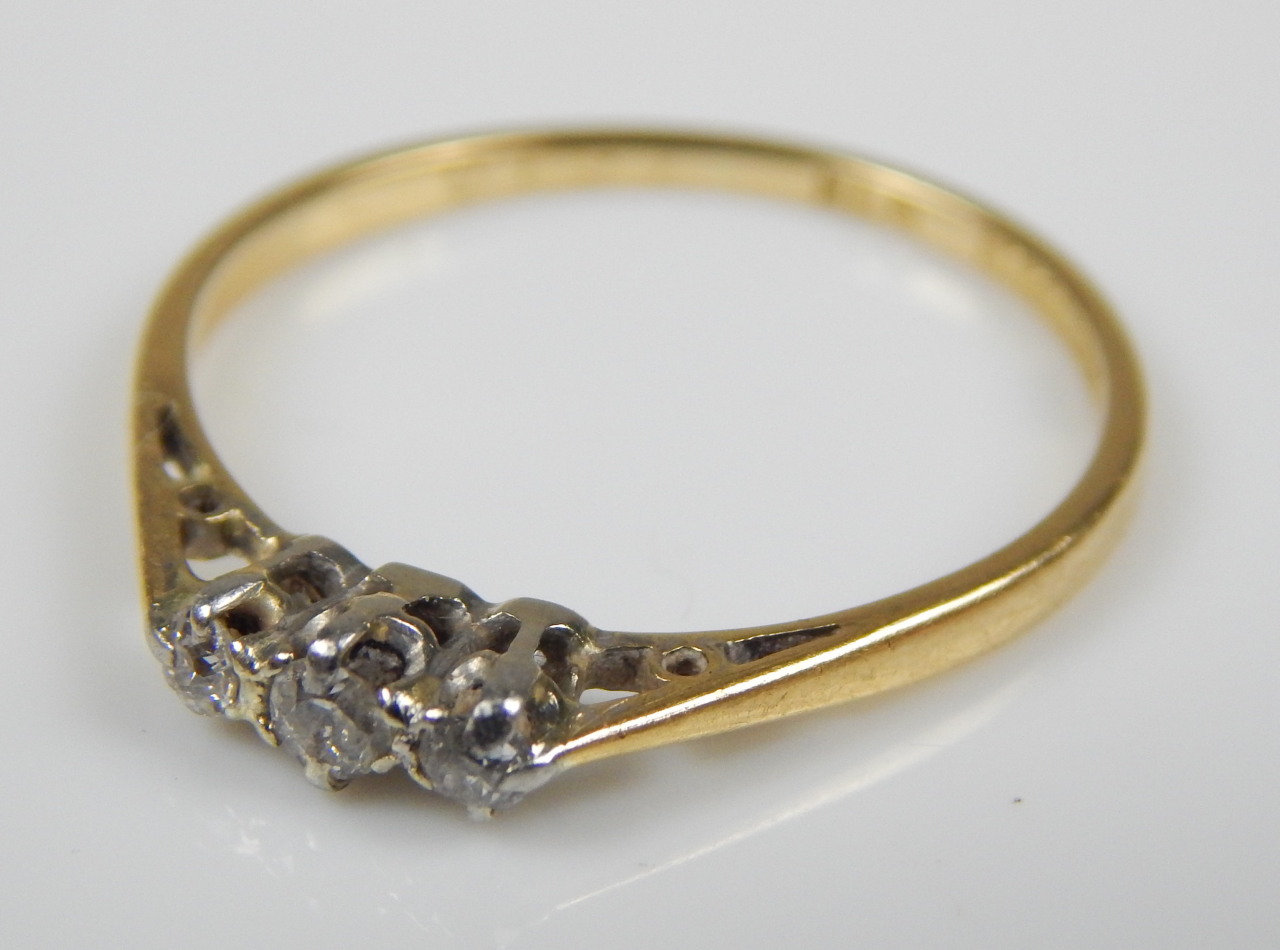 Appraisal: A three stone diamond ring with three tiny diamonds yellow