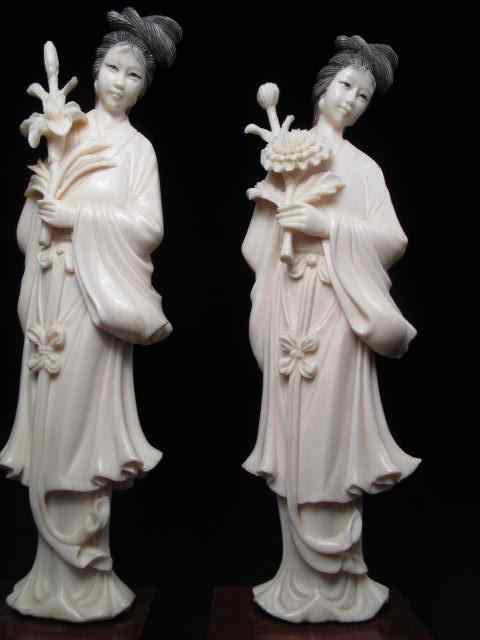 Appraisal: Pair of carved ivory figurines Each depicts a woman with