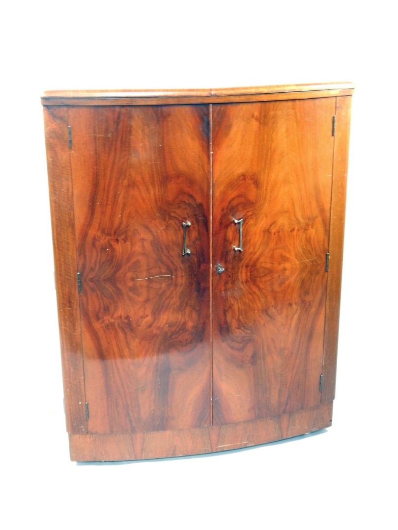 Appraisal: A 's figured walnut bow fronted cocktail cabinet enclosed by