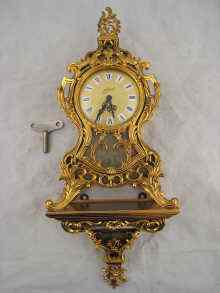 Appraisal: A gilt mechanical alarm clock on conforming bracket overall ht