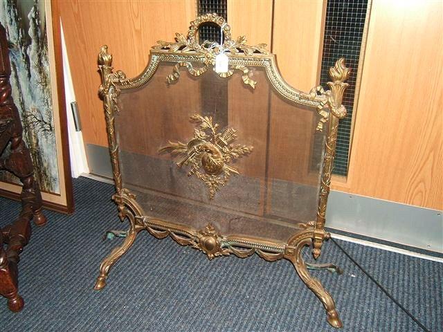 Appraisal: A Continental style brass fire guard decorated with ribbon tied