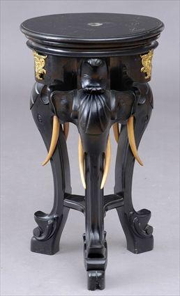 Appraisal: ANGLO INDIAN EBONIZED WOOD PEDESTAL The circular top on elephant-head