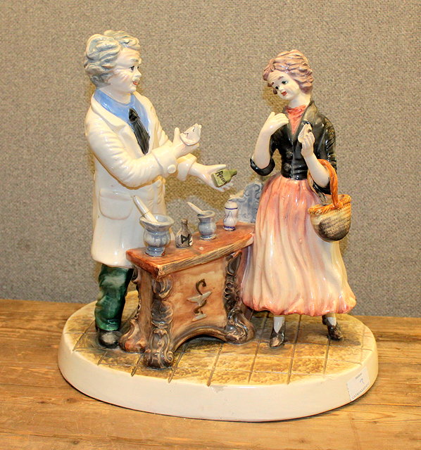 Appraisal: AN ITALIAN POTTERY FIGURAL GROUP of a chemist and his