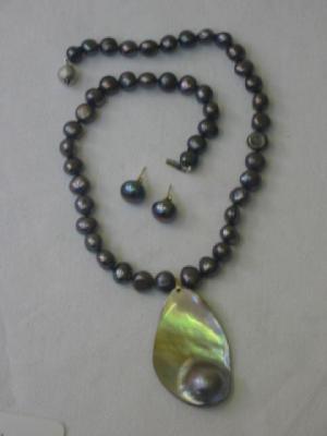 Appraisal: A CULTURED BLACK BAROQUE PEARL NECKLACE with mabe pearl pendant