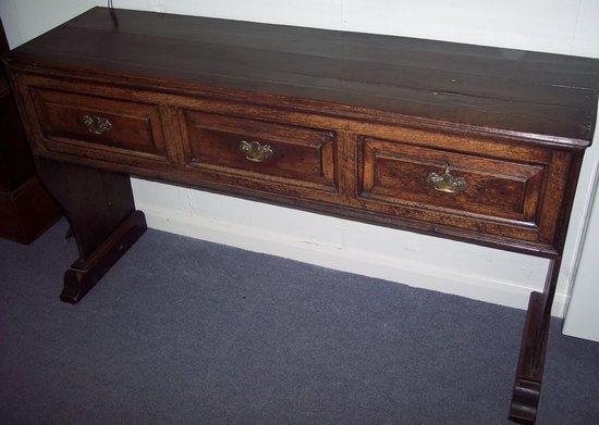 Appraisal: An oak dresser fitted three drawers on shaped end supports