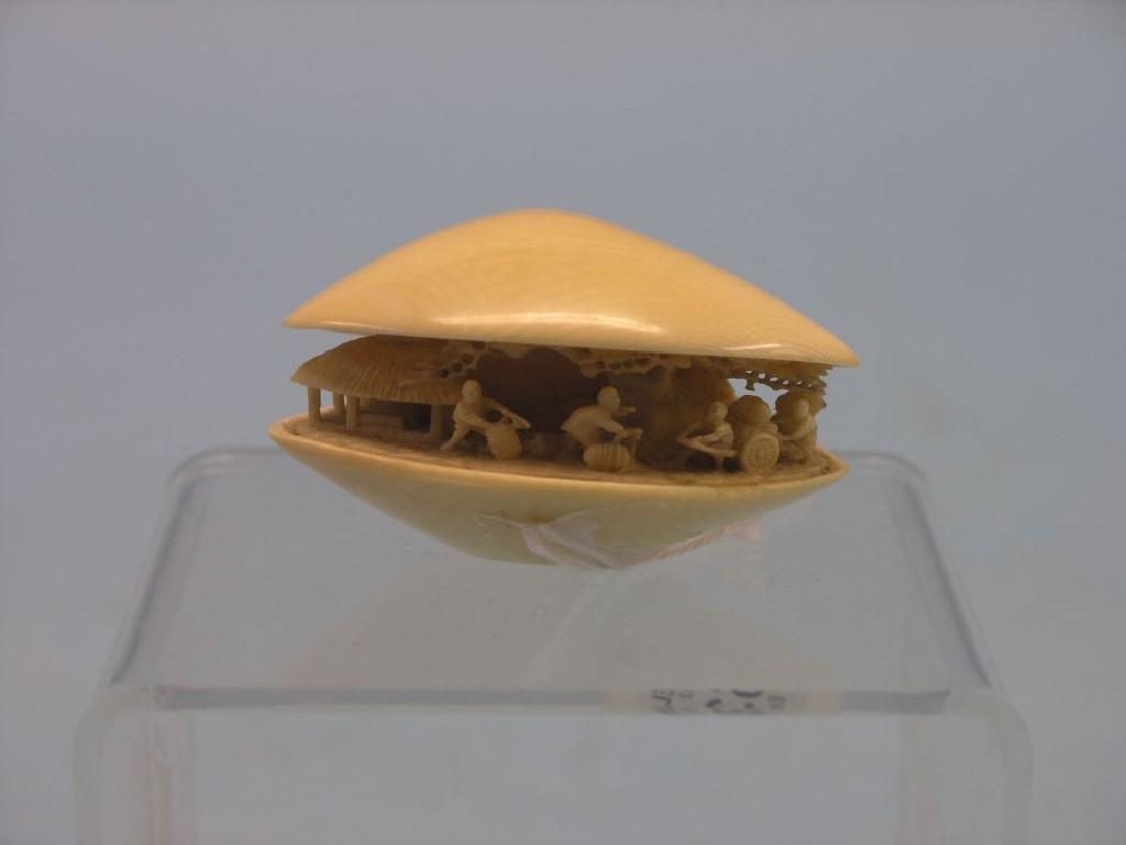 Appraisal: A Japanese ivory okimono clam shell with internal village scene