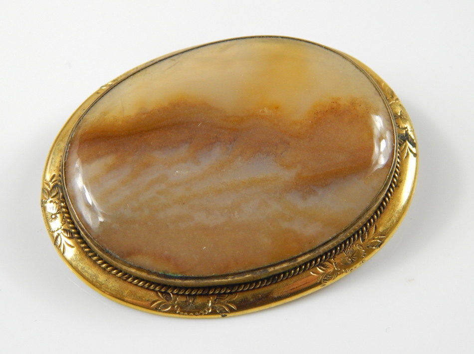 Appraisal: An oval agate brooch in a gold plated floral engraved