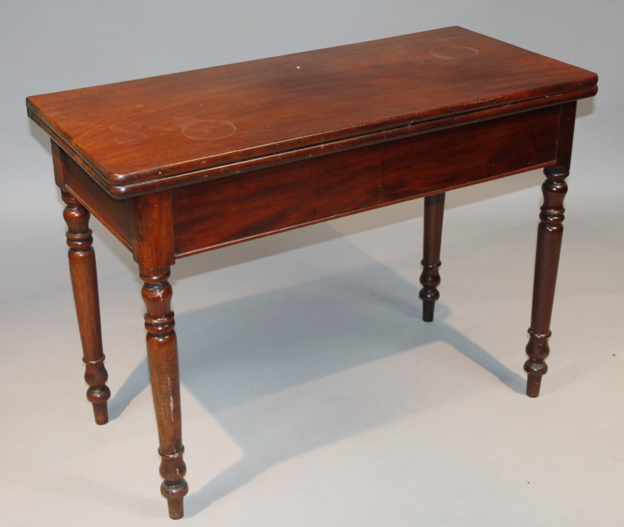 Appraisal: A thC mahogany fold-over table the overhanging top raised on