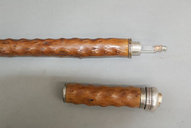 Appraisal: An English walking cane containing a fine long glass bottle