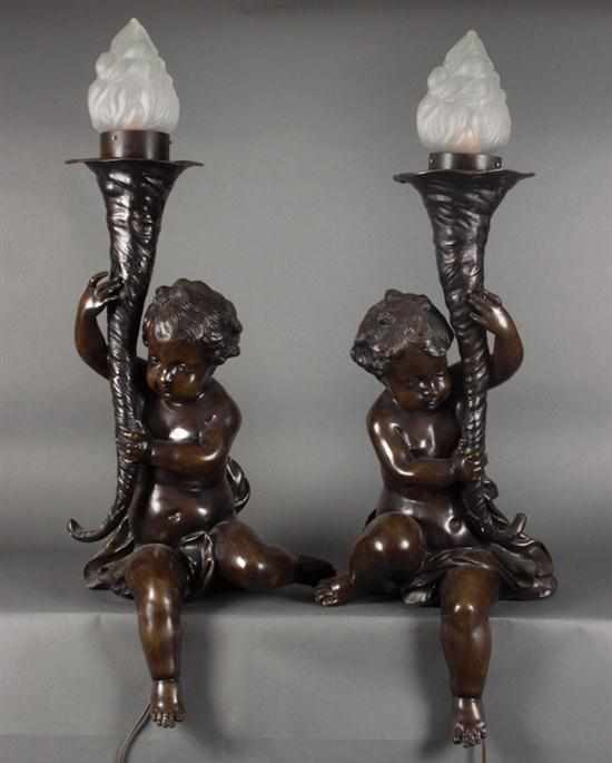 Appraisal: Pair of bronze putti lamps th century brown patina each