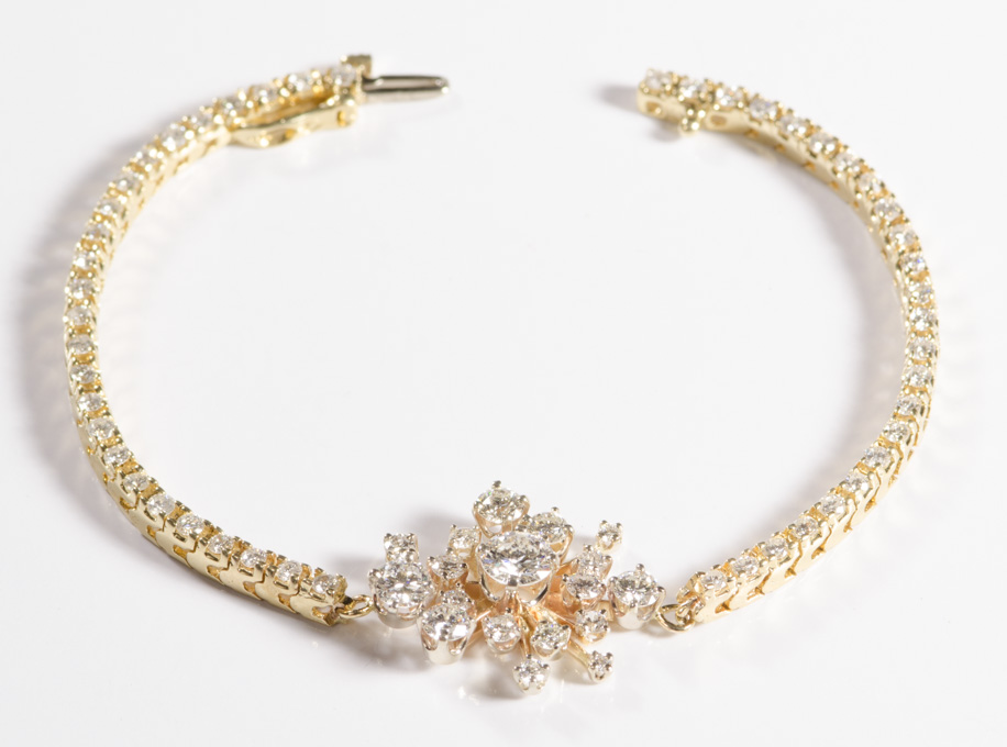 Appraisal: DIAMOND AND FOURTEEN KARAT GOLD BRACELET featuring a snowflake-like cluster