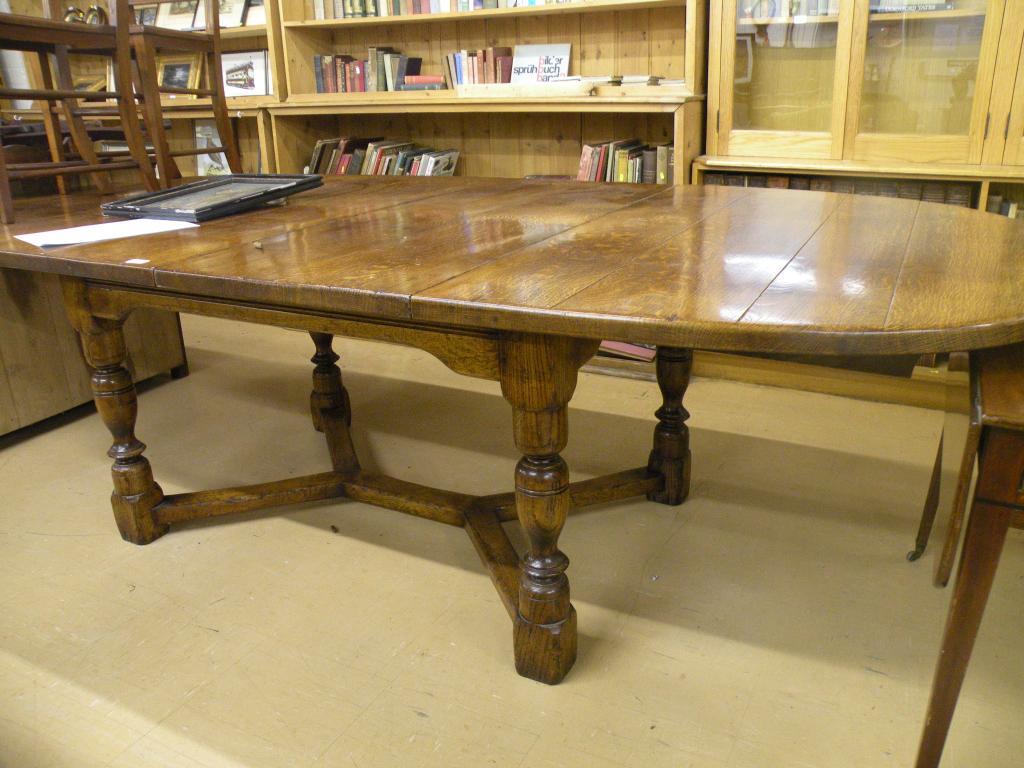 Appraisal: An oak extending dining table on turned supports with low