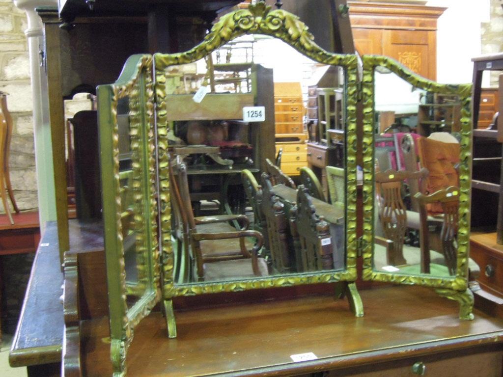 Appraisal: A triple folding dressing table mirror with shaped and gilded