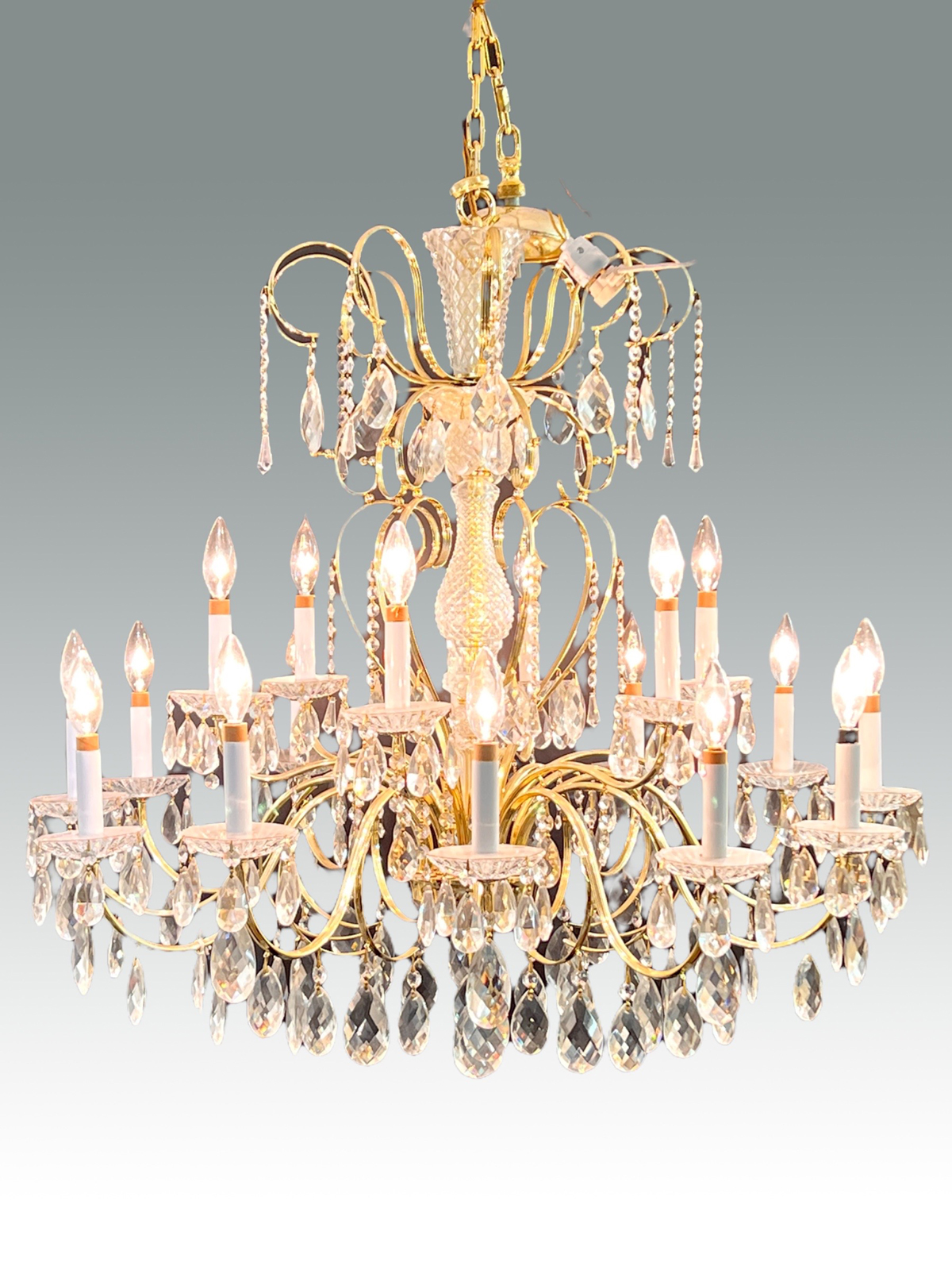 Appraisal: LIGHT BRASS CRYSTAL CHANDELIER Scrolling brass frame with - lights