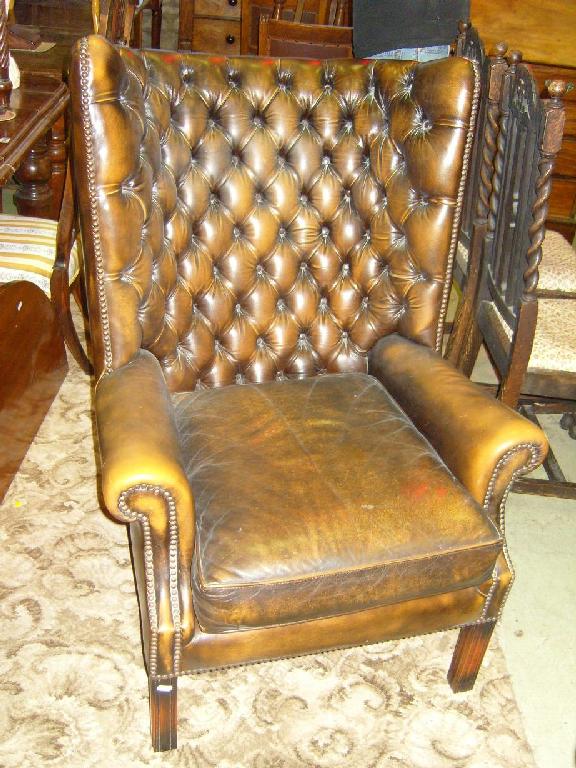 Appraisal: A Georgian style wing back armchair leather upholstered with button