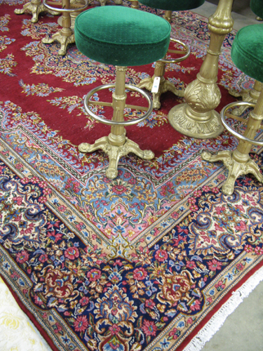 Appraisal: PERSIAN ROYAL KERMAN CARPET the plain spinner red field centering