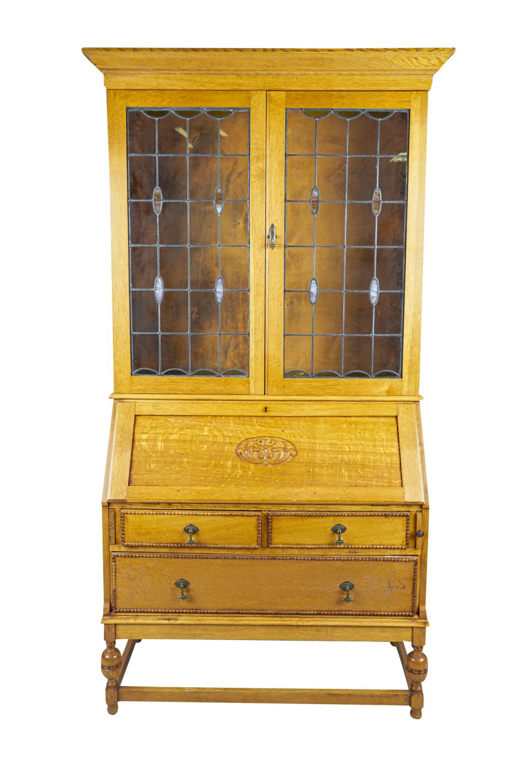 Appraisal: AMERICAN CARVED OAK LEADED GLASS BUREAU BOOKCASEthe glazed doors enclosing