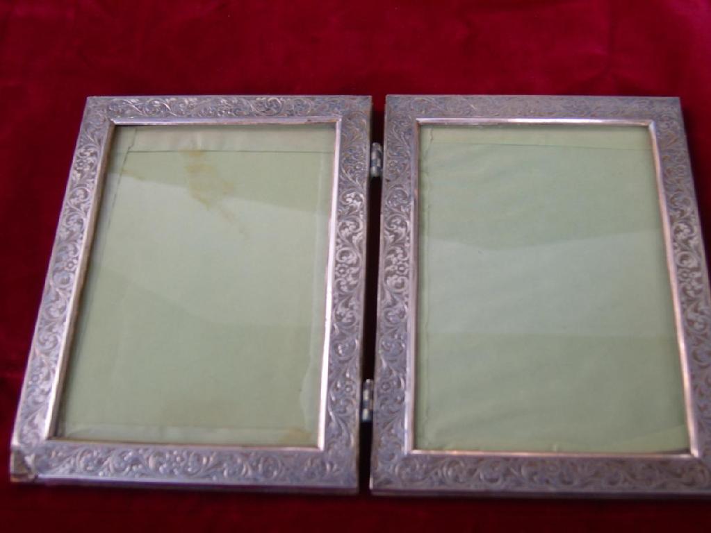 Appraisal: A continental white metal mounted folding double photo frame with