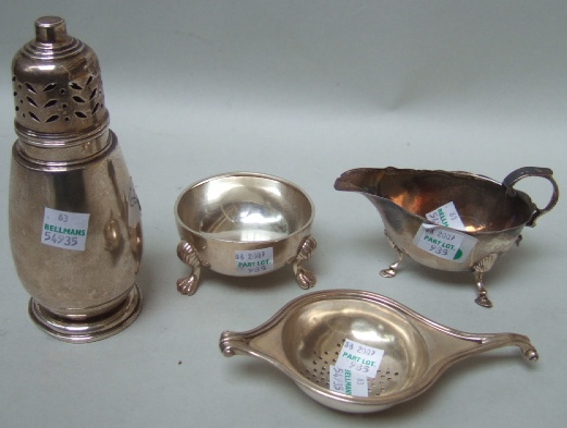 Appraisal: A tea strainer with a stand detailed 'Sterling silver' the