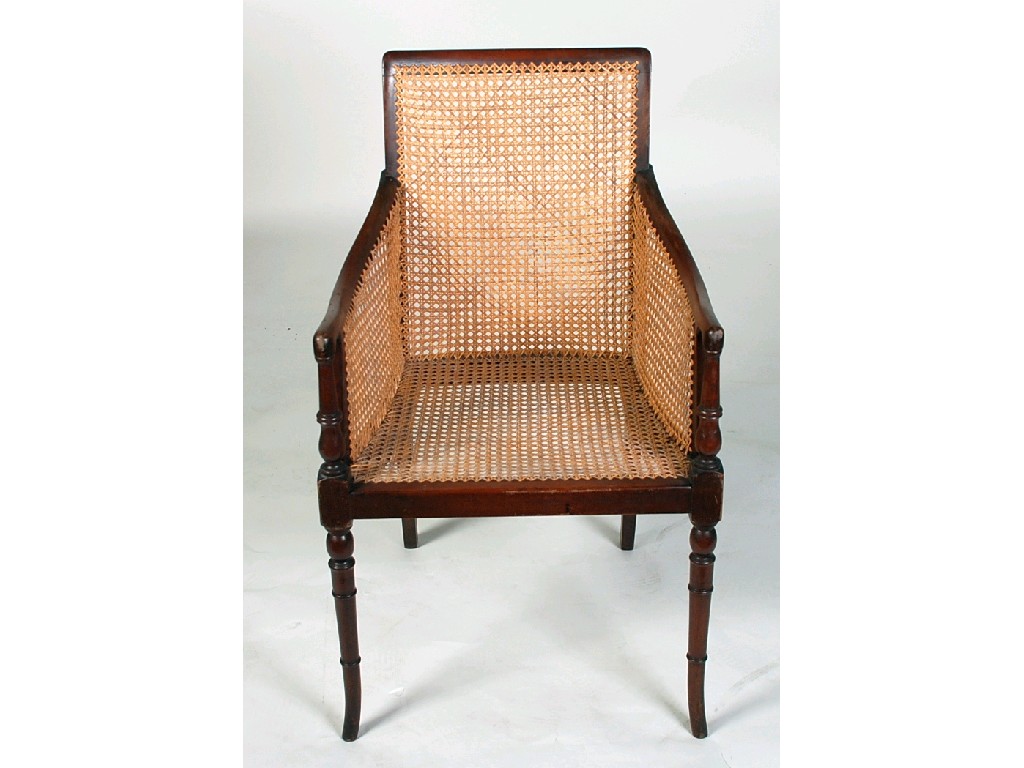 Appraisal: EARLY TWENTIETH CENTURY MAHOGANY BERGERE ARMCHAIR the hollowed top rail