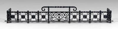 Appraisal: Wrought iron fender cast and forged elements scrolls and circular