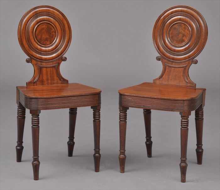 Appraisal: PAIR OF REGENCY CARVED MAHOGANY HALL CHAIRS Each dished backrest